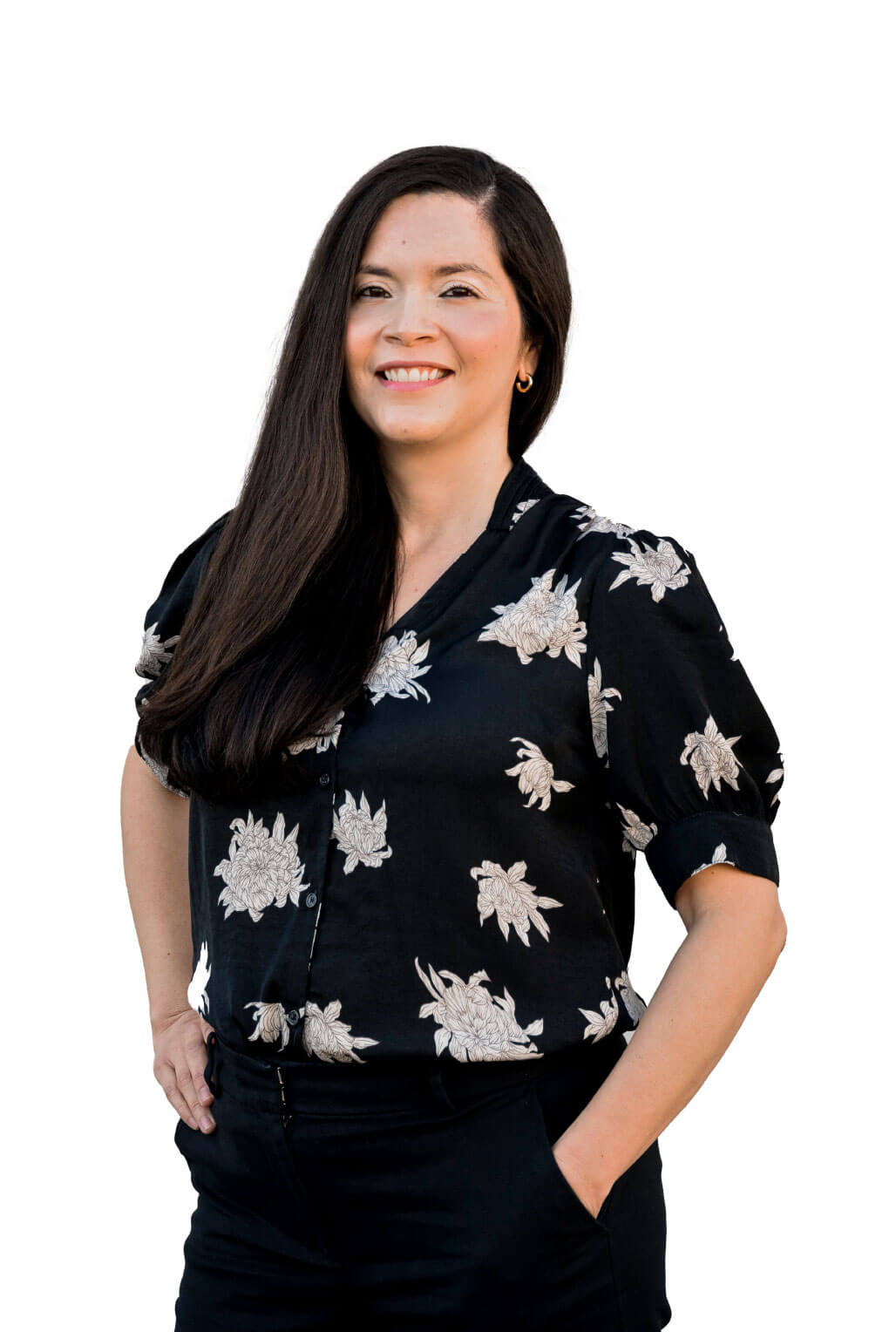 Woman smiling in floral black blouse standing.